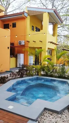 a house with a swimming pool in front of it at Hotel Tabasco in Playa Flamingo