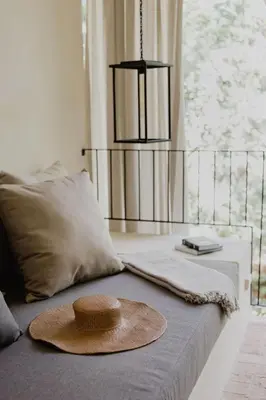 a hat sitting on top of a bed with a window at Sendero Hotel in Nosara