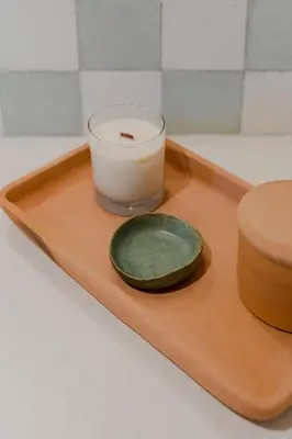 a candle and a glass on a wooden tray at Sendero Hotel in Nosara