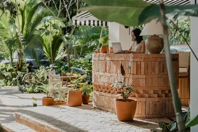 a woman sitting at a table with a laptop at Sendero Hotel in Nosara