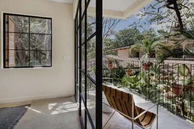 a room with a balcony with chairs and a window at Sendero Hotel in Nosara