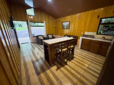 a kitchen and living room with a table and chairs at Eco Finca Tucan in Monteverde Costa Rica
