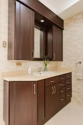 a bathroom with a sink and wooden cabinets at XIN Bed&Breakfast in San José