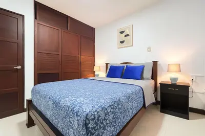 a bedroom with a bed with blue sheets and blue pillows at XIN Bed&Breakfast in San José