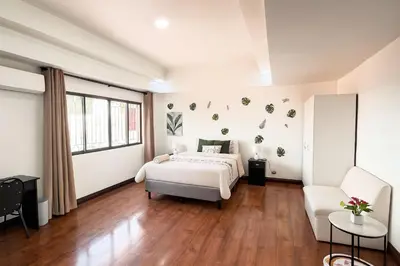 a bedroom with a bed and a couch and a chair at XIN Bed&Breakfast in San José
