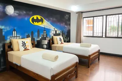two beds in a room with a batman mural at XIN Bed&Breakfast in San José