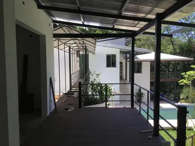 an external view of a house with a wooden walkway at Jungle Villa copa de árbol, oceanview, infinity in Montezuma