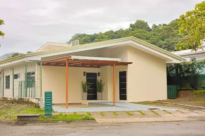 a small white house with an open garage at Casa en puntaleona Condomio Bambu in Quebrada Ganado
