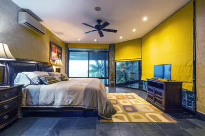 a bedroom with a bed and a flat screen tv at Beautiful estate in quiet surroundings close to beach in Naranjito