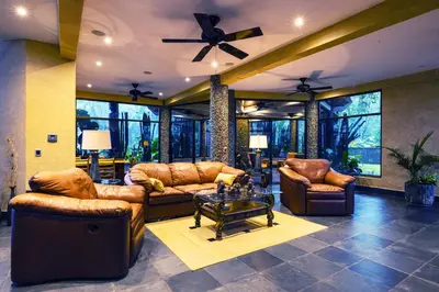 a living room with leather furniture and a table at Beautiful estate in quiet surroundings close to beach in Naranjito