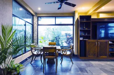 a dining room with a table and chairs and a large window at Beautiful estate in quiet surroundings close to beach in Naranjito