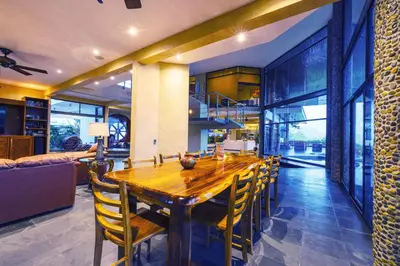 a dining room with a wooden table and chairs at Beautiful estate in quiet surroundings close to beach in Naranjito