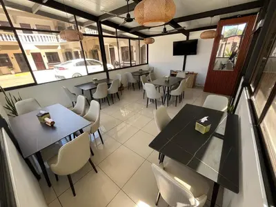 a restaurant with tables and chairs in a room at Hotel Wilson Anexo in Liberia