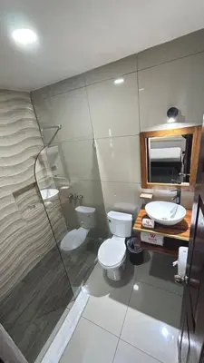 a bathroom with a toilet and a sink and a shower at Hotel Wilson Anexo in Liberia