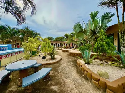 a resort with two blue benches in a pond at Hotel Wilson Upala in Upala
