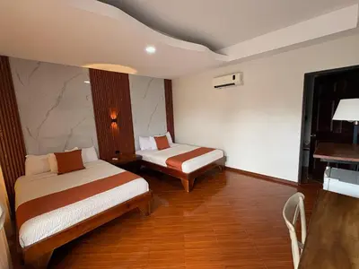 a hotel room with two beds and a table at Hotel Wilson Upala in Upala