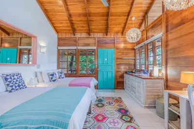 a bedroom with two beds and a wooden ceiling at Hotel Guiones in Nosara