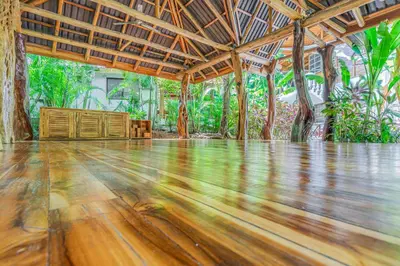 an empty room with a wooden floor and a wooden ceiling at Hotel Guiones in Nosara