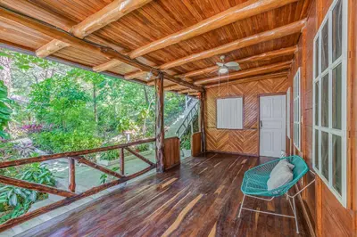 an empty room with a chair on a porch at Hotel Guiones in Nosara