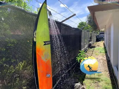 a surfboard is leaning against a fence at Beach house Matapalo Santa Cruz in Matapalo