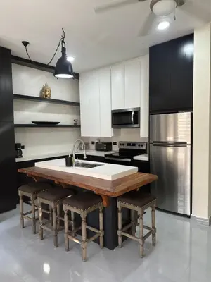 a kitchen with a wooden table and a sink at Central Park Apartment in Tamarindo