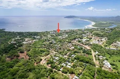 an island with a red tower in the middle of the water at Central Park Apartment in Tamarindo