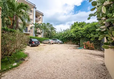 a driveway with two cars parked in front of a building at Central Park Apartment in Tamarindo