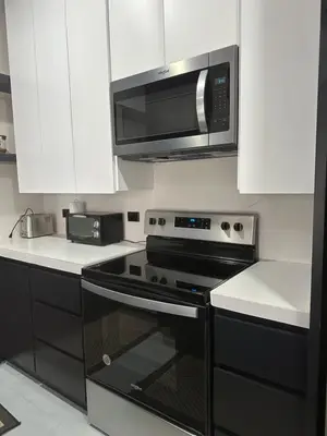 a kitchen with a black stove and a microwave at Central Park Apartment in Tamarindo