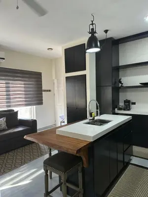 a kitchen with black cabinets and a wooden counter top at Central Park Apartment in Tamarindo