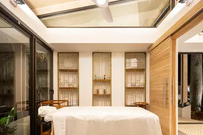 a room with a bed and some glass doors at The Gilded Iguana in Nosara