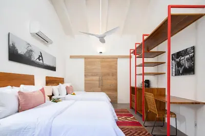 a bedroom with two beds and a staircase at The Gilded Iguana in Nosara