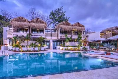 an exterior view of a resort with a swimming pool at The Gilded Iguana in Nosara