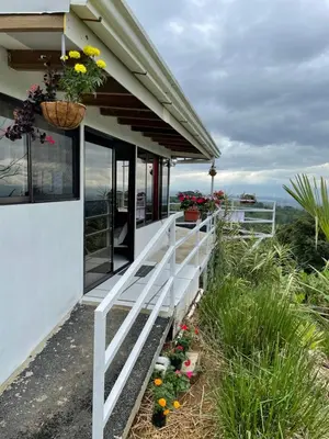 a white house with flowers on the side of it at Casa Panorámica con Jacuzzi balcon. Familia Amigos in Robles
