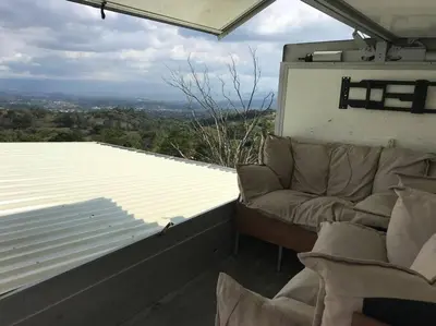 a living room with a couch and a large window at Casa Panorámica con Jacuzzi balcon. Familia Amigos in Robles