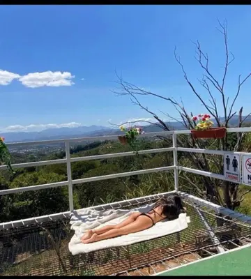 a woman laying on a hammock in a tree at Casa Panorámica con Jacuzzi balcon. Familia Amigos in Robles