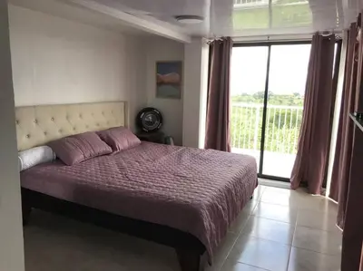 a bedroom with a bed and a large window at Casa Panorámica con Jacuzzi balcon. Familia Amigos in Robles