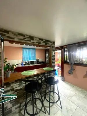 a kitchen with two bar stools and a counter at Dreams Lodge Orosi in Cartago