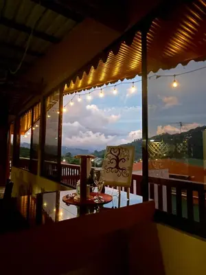 a table and chair on a balcony with a view at Dreams Lodge Orosi in Cartago