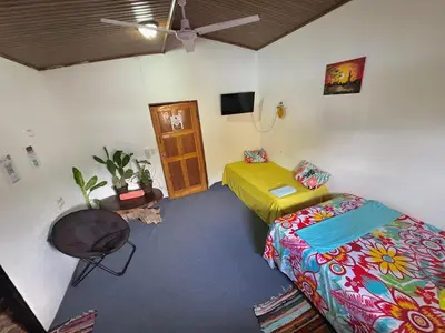 a room with two beds and a table at Passifloras Hostel in Quepos