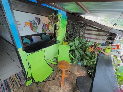 a room with a couch and a table and a chair at Passifloras Hostel in Quepos