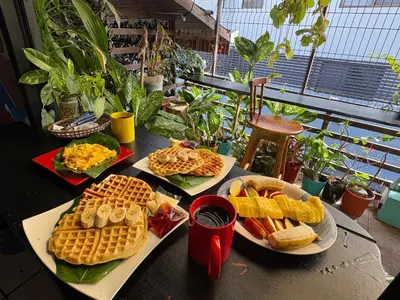 a table with three plates of waffles and waffleergy at Passifloras Hostel in Quepos