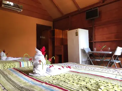 a room with two beds and a refrigerator at Hotel Villas Vista Arenal in Fortuna