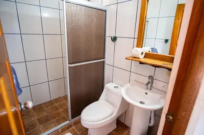 a small bathroom with a toilet and a sink at Hotel Sierra Arenal in Fortuna