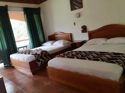 a bedroom with two beds and a window at Hotel Sierra Arenal in Fortuna