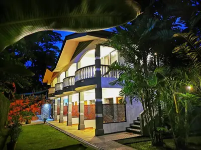 a building with a palm tree in front of it at Hotel Sierra Arenal in Fortuna