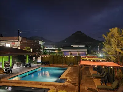 a swimming pool at night with a mountain in the background at San Bosco Inn in Fortuna