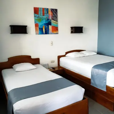 a room with two beds and a painting on the wall at San Bosco Inn in Fortuna