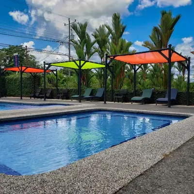a swimming pool with orange and yellow umbrellas at San Bosco Inn in Fortuna