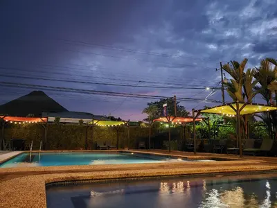 a swimming pool at night with an umbrella at San Bosco Inn in Fortuna