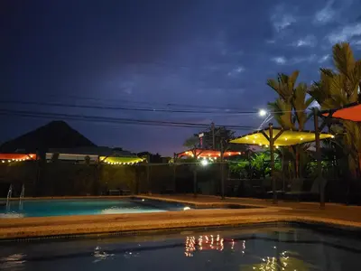 a swimming pool at night with an umbrella at San Bosco Inn in Fortuna